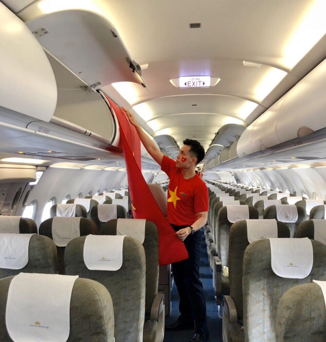 Tiếp vi&ecirc;n Nguyễn Hữu Trung chỉnh trang l&aacute; cờ Tổ quốc tr&ecirc;n m&aacute;y bay ch&agrave;o đ&oacute;n c&aacute;c vận động vi&ecirc;n Việt Nam.