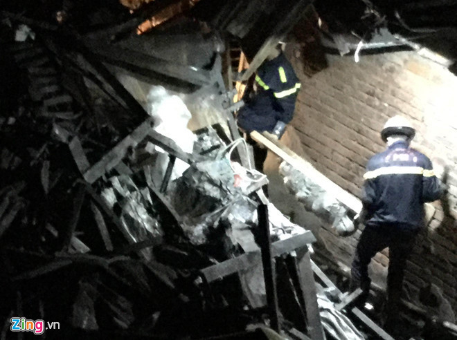 Cơ quan chức năng đưa 2 thi thể từ hiện trường vụ ch&aacute;y ra ngo&agrave;i. Ảnh:&nbsp;Trần Anh.