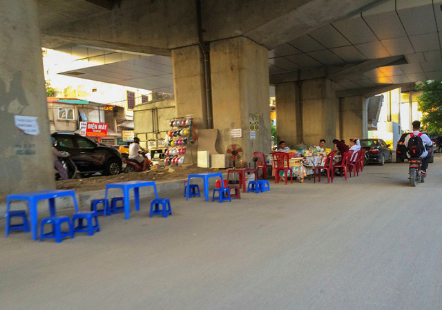 C&ograve;n tại khu vực gầm cầu đường sắt tr&ecirc;n cao ở đối diện bến xe Y&ecirc;n Nghĩa (H&agrave; Đ&ocirc;ng), người d&acirc;n tự &yacute; mở qu&aacute;n tr&agrave; đ&aacute; dưới gầm cầu, ngang nhi&ecirc;n k&ecirc; b&agrave;n ghế tr&agrave;n lan.