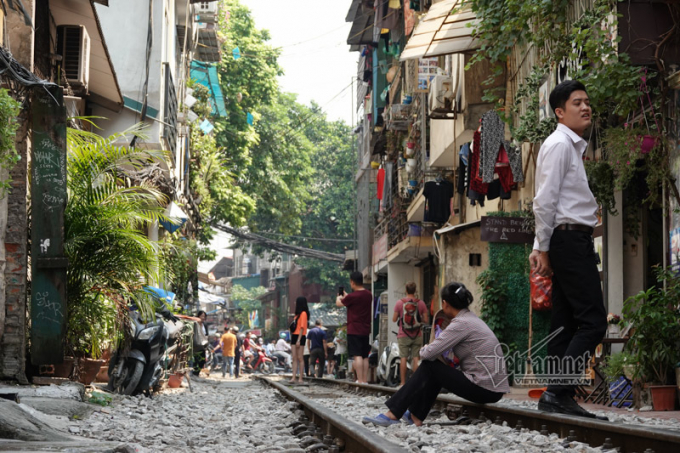 Người đứng, kẻ ngồi trên đường ray, mỗi ngày có hàng chục chuyến tàu chạy qua đây.