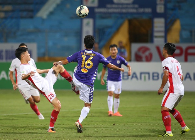 Hoàng Đức (trái) lao vào tranh bóng với Thành Chung (giữa)