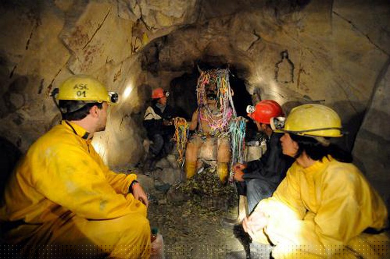 Du khách xem thợ mỏ dâng lễ tới tượng quỷ thần El Tio trong một khu hầm mỏ dưới chân núi Cerro Rico.