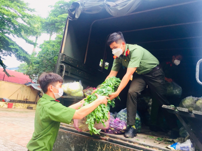 Thường trực Đoàn Thanh niên Công an tỉnh - Thượng úy Lại Tiến Sĩ (thứ hai, trái sang) đang vận chuyển rau xanh trên xe xuống tập kết tại Tỉnh Đoàn để chờ giờ khởi hành đến vùng dịch Bình Dương