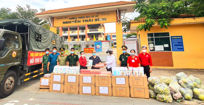 Bà Nguyễn Thị Lệ Trinh, Chủ tịch Hội CTĐ tỉnh Bình Dương (thứ 5, trái sang) và ông Tống Xuân Giang, Phó Chủ tịch Hội CTĐ tỉnh Bình Dương (bìa phải) trao quà của Bình Phước cho khu cách ly tại Trường THCS Nguyễn Thái Bình.