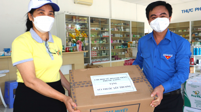 Bí thư Tỉnh Đoàn Bình Phước Trần Quốc Duy (phải) và bà Giang Thị Lan Thu - Chủ tịch Hội Nữ doanh nhân tỉnh hối hả khiêng hàng hóa lên xe để kịp giờ khởi hành đến “tâm dịch” Bình Dương.