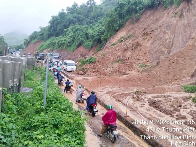 C&aacute;c phương tiện di chuyển rất kh&oacute; khăn tr&ecirc;n đoạn đường sạt lở.