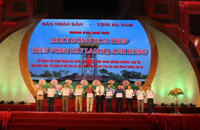 Đồng ch&iacute; Đinh Thế Huynh đ&atilde; trao sổ tiết kiệm cho th&acirc;n nh&acirc;n 10 nữ liệt sĩ d&acirc;n qu&acirc;n ph&ograve;ng kh&ocirc;ng x&atilde; Lam Hạ.