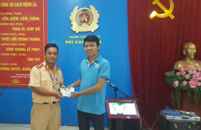 C&aacute;n bộ chiến sĩ CSGT đội 4 trao trả lại t&agrave;i sản cho anh Minh.