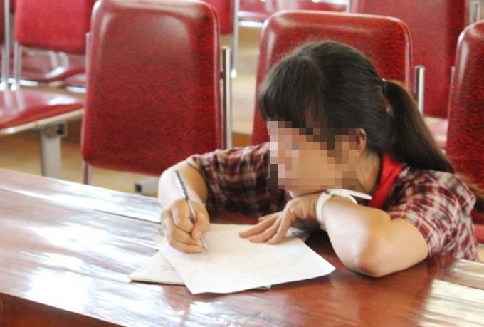 Một trong số c&aacute;c nữ sinh xuất hiện trong đoạn clip viết bản tường tr&igrave;nh tại cơ quan chức năng.