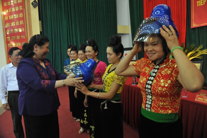 B&agrave; T&ograve;ng Thị Ph&oacute;ng - Ph&oacute; chủ tịch Quốc Hội đang trao mũ cho phụ nữ d&acirc;n tộc th&aacute;i tại Sơn La.