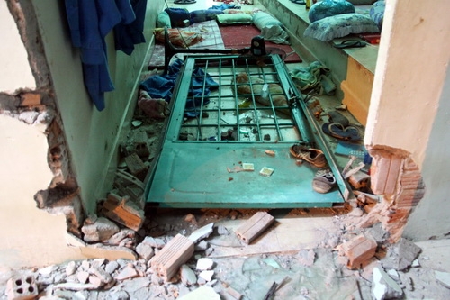 Một c&aacute;nh cửa bị đập vỡ, x&ocirc; đạp v&agrave;o trong ph&ograve;ng.