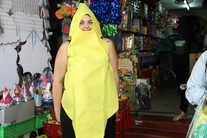 kh&aacute;ch du lịch ướm thử v&agrave;o người một bộ trang phục sặc sỡ