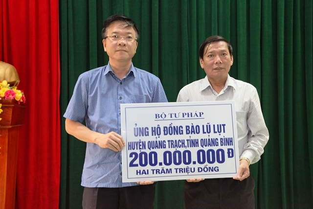 Bộ trưởng Bộ tư ph&aacute;p L&ecirc; Th&agrave;nh Long trao qu&agrave; cho đại diện nh&acirc;n d&acirc;n huyện Quảng Trạch, tỉnh Quảng B&igrave;nh.