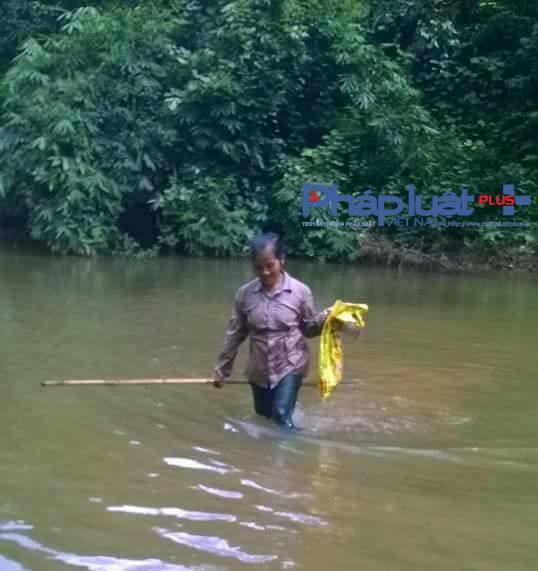 Người d&acirc;n x&atilde; Thổ B&igrave;nh tiếp tục vớt c&aacute; chết dưới l&agrave;n nước suối lờ lờ đỏ đục.