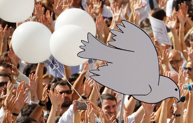 Đ&aacute;m đ&ocirc;ng biểu t&igrave;nh h&ocirc; vang khẩu hiệu &ldquo;Ch&uacute;ng t&ocirc;i muốn đ&agrave;m ph&aacute;n&rdquo;, v&agrave; giơ cao c&aacute;c biểu tượng thể hiện h&ograve;a b&igrave;nh như chim bồ cầu trắng, b&oacute;ng bay. (Ảnh: RT)