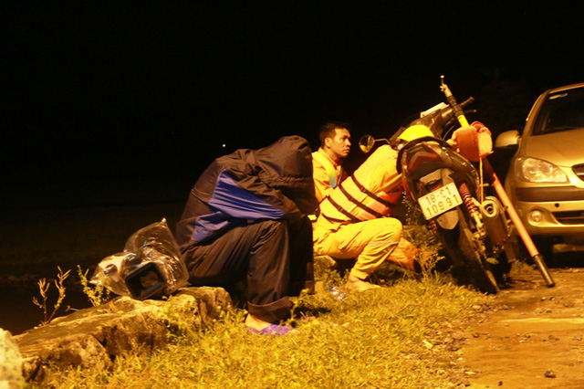 Một ph&oacute;ng vi&ecirc;n (&aacute;o mưa đen) c&oacute; mặt tại đập tr&agrave;n Lạc Kho&aacute;i, ngồi c&ugrave;ng lực lượng chức năng canh diễn biến thi&ecirc;n tai. Sau một ng&agrave;y