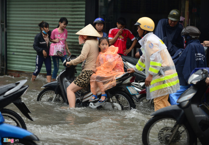 Cảnh s&aacute;t giao th&ocirc;ng cố gắng điều tiết giao th&ocirc;ng. Đến 8h c&ugrave;ng ng&agrave;y nước vẫn chưa r&uacute;t hết, người d&acirc;n b&igrave; b&otilde;m đi lại.