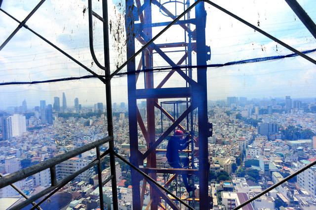 Những người l&agrave;m nghề l&aacute;i cẩu th&aacute;p quanh nắm suốt th&aacute;ng l&agrave;m việc giữa lưng chừng trời. V&otilde; Văn Lợi (25 tuổi, qu&ecirc; An Giang) l&agrave; một trong những người l&aacute;i cẩu th&aacute;p tại c&ocirc;ng trường x&acirc;y dựng ở TPHCM.