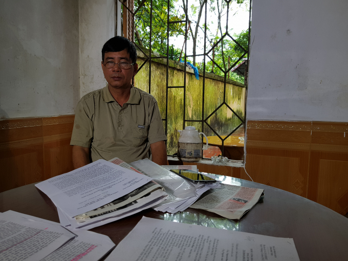 &Ocirc;ng Sự thẫn thờ b&ecirc;n những t&agrave;i liệu k&ecirc;u oan cho con g&aacute;i.