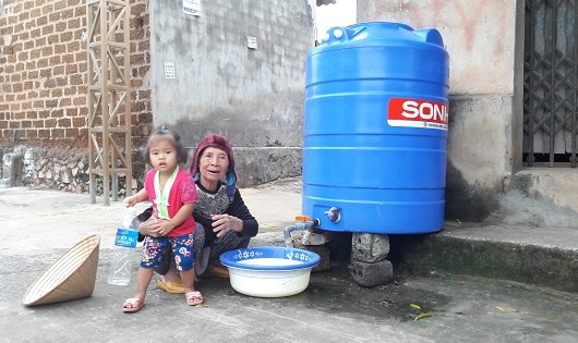 Nước đ&atilde; r&uacute;t nhưng nguồn nước giếng &ocirc; nhiễm, người d&acirc;n vẫn chia nhau từng chậu nước ch&iacute;nh quyền cấp.
