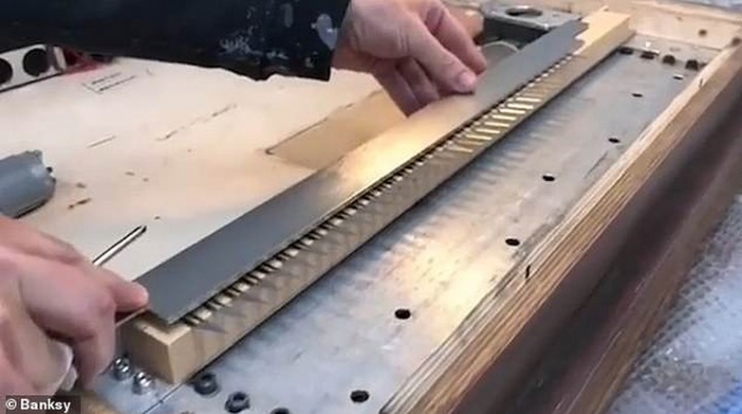 Đoạn clip do họa sỹ Banksy đăng tải tr&ecirc;n trang Instagram m&agrave; &ocirc;ng x&oacute;a ngay sau đ&oacute; cho thấy, họa sỹ n&agrave;y đ&atilde; c&agrave;i một thiết bị cắt giấy v&agrave;o bức tranh, được điều khiển bằng thiết bị từ xa. Ảnh: Banksy.