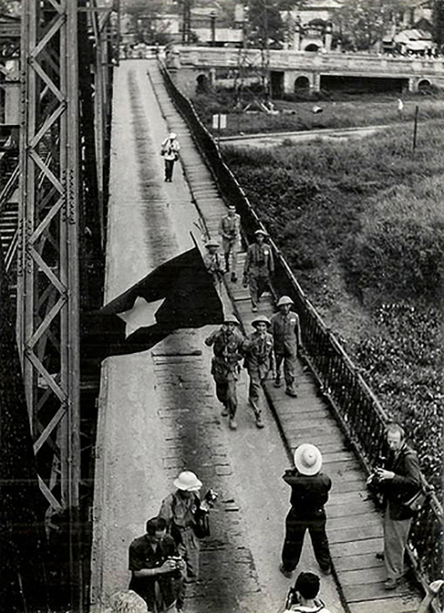 1954:&nbsp;Trong khi lực lượng viễn chinh Ph&aacute;p thất thểu r&uacute;t lui, th&igrave; b&ecirc;n kia cầu Long Bi&ecirc;n, đo&agrave;n qu&acirc;n Việt Minh h&ugrave;ng dũng tiến v&agrave;o H&agrave; Nội trong tiếng h&ograve; reo của người d&acirc;n&hellip; Trong ảnh l&agrave;&nbsp;những người l&iacute;nh Việt Nam tiến qua cầu Long bi&ecirc;n c&ugrave;ng l&aacute; cờ đỏ, sao v&agrave;ng tr&ecirc;n tay.&nbsp;