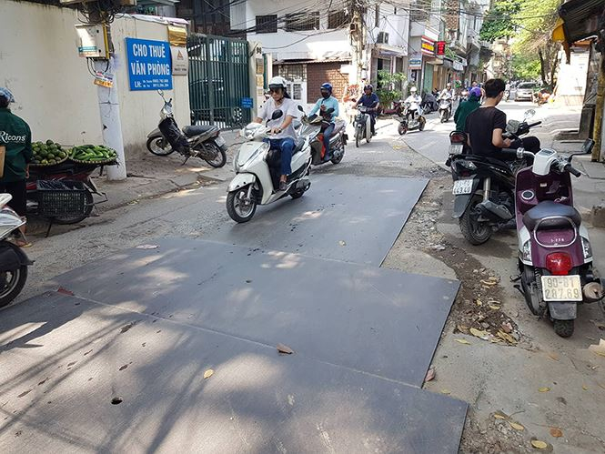 Tại phố Lương Y&ecirc;n (quận Hai B&agrave; Trưng), bắt đầu từ số nh&agrave; 94 Lương Y&ecirc;n đến hết phố, to&agrave;n bộ mặt đường bị c&agrave;y xới, che chắn tạm bằng những miếng th&eacute;p lớn. Tuy nhi&ecirc;n, c&ocirc;ng tr&igrave;nh đ&agrave;o đường diễn ra hơn 2 tuần nay v&ocirc; c&ugrave;ng bụi bặm khiến b&agrave; con bu&ocirc;n b&aacute;n tại đ&acirc;y bị ảnh hưởng kh&ocirc;ng nhỏ.