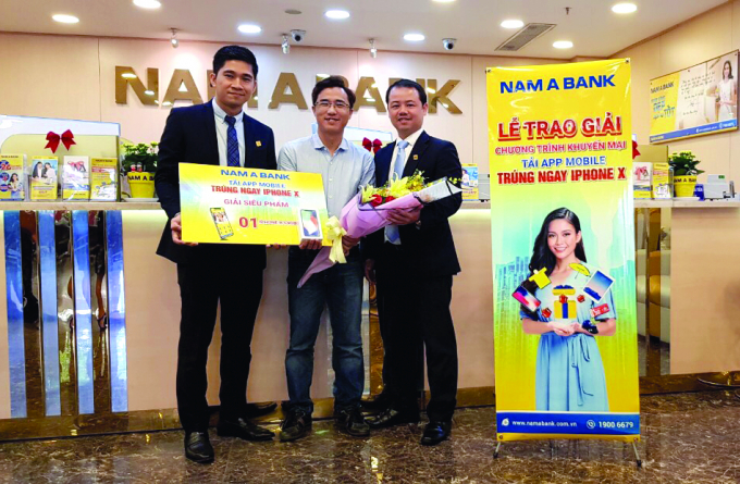 &Ocirc;ng Nguyễn Quang Th&ocirc;ng - Gi&aacute;m đốc Trung t&acirc;m Ng&acirc;n h&agrave;ng số v&agrave; &ocirc;ng Nguyễn Quốc Kh&aacute;nh - Gi&aacute;m đốc Nam A Bank H&ograve;a B&igrave;nh trao giải Si&ecirc;u phẩm l&agrave; 1 chiếc iPhone X cho Kh&aacute;ch h&agrave;ng Nguyễn Ngọc Dương.