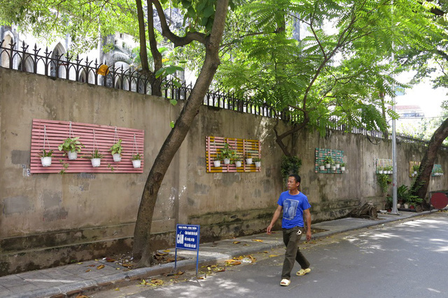 Phố Ấu Triệu (quận Ho&agrave;n Kiếm) với bức tường được trang tr&iacute; bằng nhiều chậu c&acirc;y treo tr&ecirc;n những tấm gi&aacute;t giường sơn nhiều m&agrave;u.