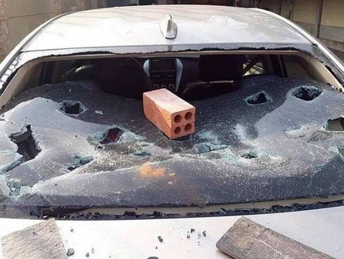 Chiếc ô tô đỗ ở cửa quán karaoke bị đập phá trong cuộc hỗn chiến. Ảnh: LT.