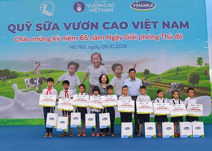 Bà Trương Thị Mai - Ủy viên Bộ Chính trị, Bí thư Trung ương Đảng, Trưởng ban Dân vận Trung ương cùng đại biểu khách mời trao học bổng và sữa của Quỹ Sữa Vươn Cao Việt Nam cho các em học sinh khó khăn có thành tích học tập tốt của trường Tiểu học Tiên Dược B, Hà Nội