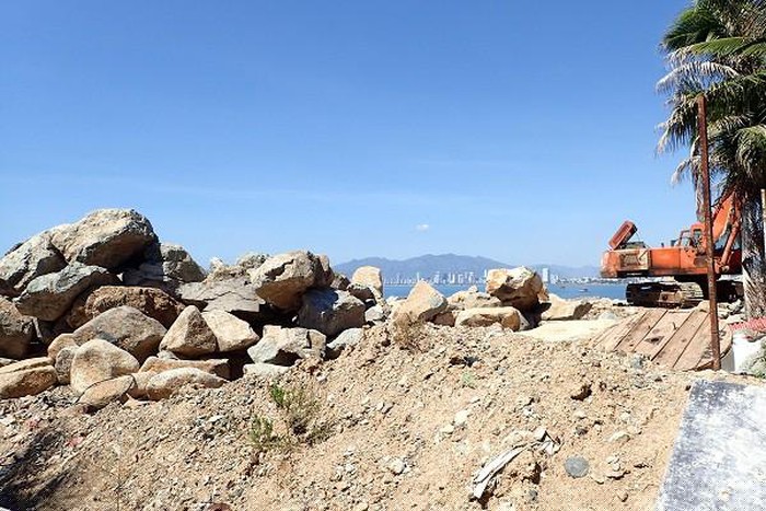 Máy xúc đưa đá đổ xuống vịnh Nha Trang. Ảnh Minh Ngọc.