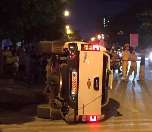 Sau khi tông 2 thanh niên đi xe máy văng lên vỉa hè, chiếc ôtô bán tải trượt dài rồi lật nghiêng.