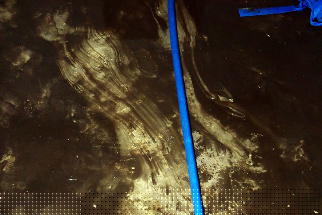 Sàn một khoang bể với lớp cặn dầu thải nhầy nhụa.