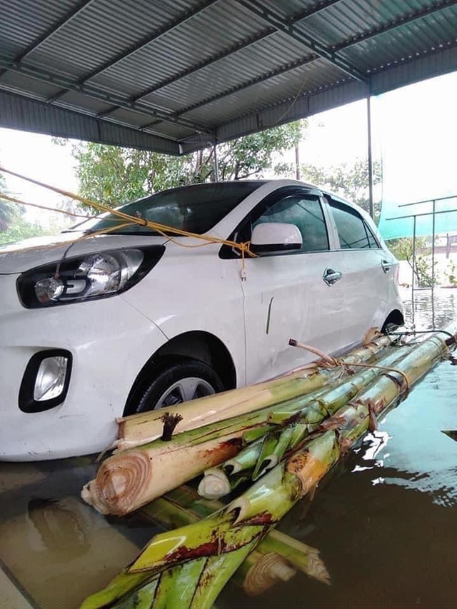 Chủ xe này đã kết bè mảng bằng cây chuối rồi đỡ ở gầm và xung quanh thân xe. Nước dâng đến đâu thì xe được nâng lên đến đó dù vẫn bị ngập tới mép cửa. Dây điện được buộc vào gương để tránh xe bị trôi.
