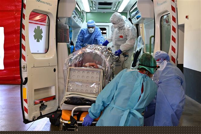 Nhân viên y tế chuyển bệnh nhân COVID-19 tới bệnh viện tại Varese, Italy, ngày 19/10/2020. Ảnh: AFP/ TTXVN