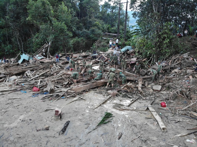 Lực lượng cứu hộ đào bới, đưa thi thể nạn nhân ra ngoài. 