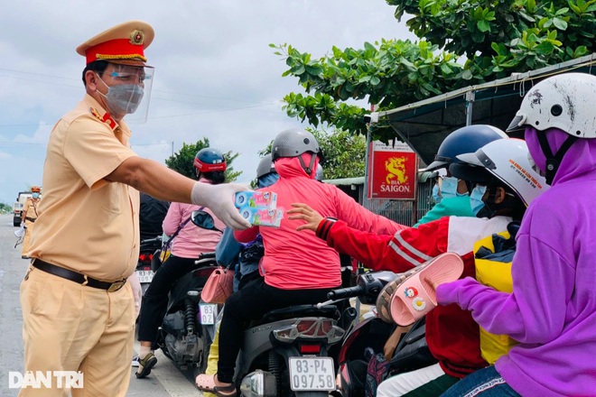 CSGT Sóc Trăng tiếp tế nước, sữa cho công dân trên đường hồi hương (Ảnh: Xuân Lương).