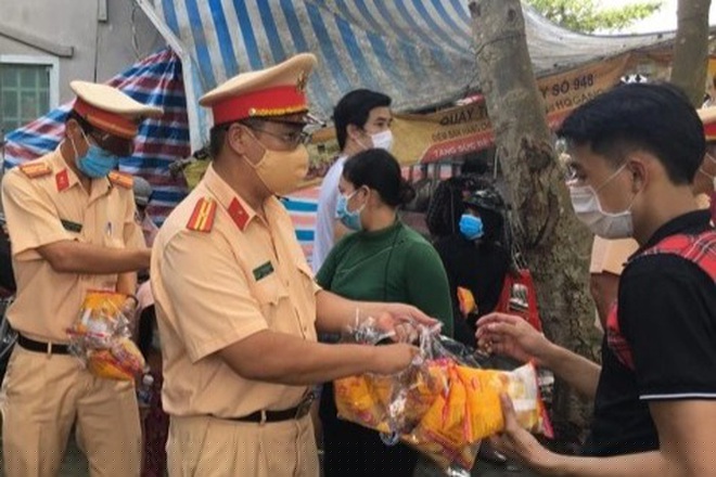 CSGT Bến Tre mời bà con ăn bánh, uống nước tại chốt kiểm soát dịch cầu Rạch Miễu (ảnh: CTV).