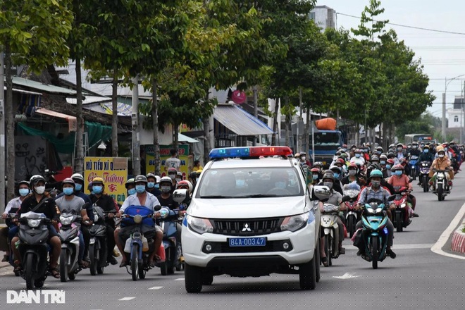 Xe của lực lượng chức năng dẫn đoàn đưa người dân hồi hương về khu cách ly (Ảnh: Hồ Giang).