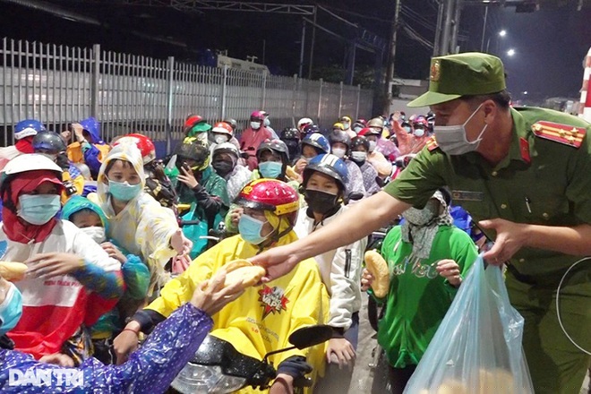 Công an An Giang hỗ trợ đồ ăn thức uống cho người dân hồi hương (Ảnh: Tiến Tầm).