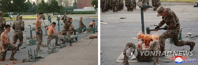 Binh sĩ Triều Ti&ecirc;n d&ugrave;ng b&uacute;a đập vỡ gạch đặt tr&ecirc;n người (Ảnh: Yonhap).