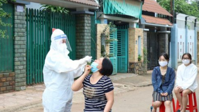 Nhân viên y tế lấy mẫu xét nghiệm cho người dân tại nơi xảy ra chùm ca bệnh ngoài cộng đồng ở TP Buôn Ma Thuột( Ảnh: N.H).