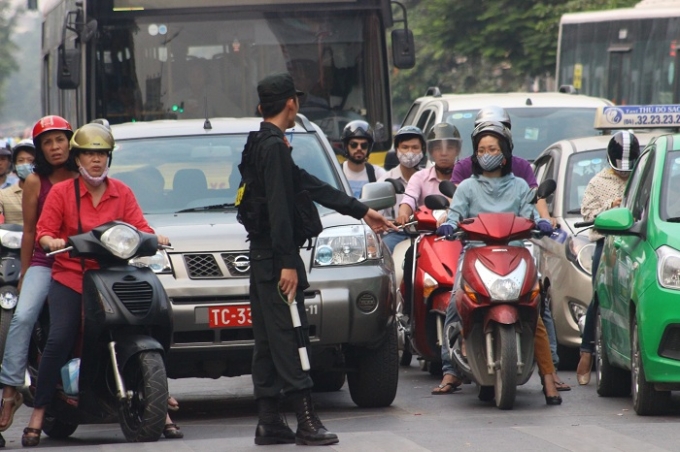 Lực lượng chức năng tổ chức ph&acirc;n luồng giao th&ocirc;ng trong t&igrave;nh trạng &ugrave;n ứ tại nhiều tuyến phố (Ảnh: Văn Đại).