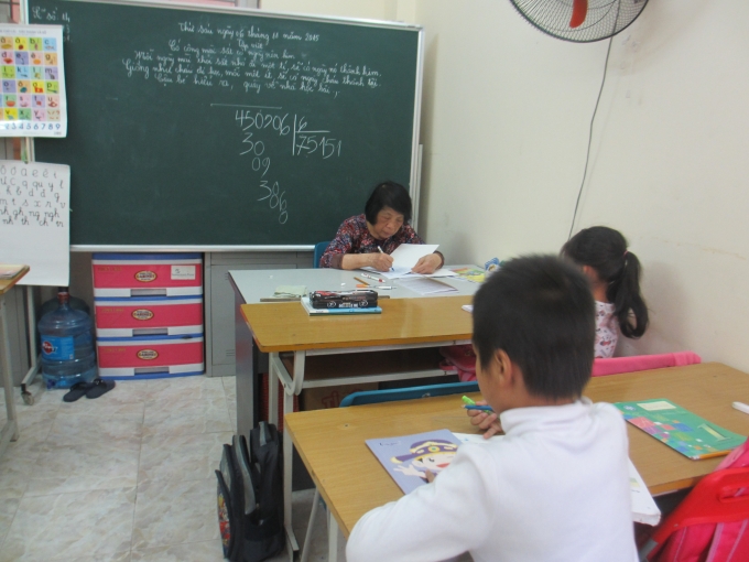 Mặc d&ugrave; đang l&agrave; giờ ra chơi nhưng c&ocirc; C&ocirc;i vẫn tranh thủ chấm b&agrave;i cho học sinh (Ảnh: Mẫn Nhi)
