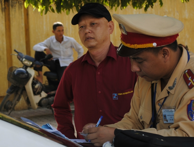 CSGT đang lập bi&ecirc;n bản với t&agrave;i xế vi phạm luật ATGT ( ảnh Ngọc H&agrave;)