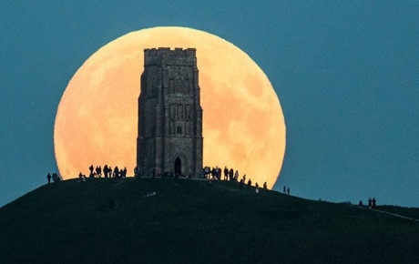 Nhiều người ngắm Si&ecirc;u Trăng từ tr&ecirc;n một đỉnh đồi ở Glastonbury Tor, Anh.