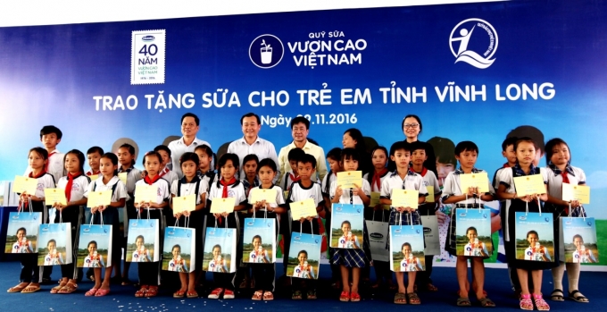 C&aacute;c đại biểu trao tặng sữa cho c&aacute;c em học sinh trường tiểu học Ho&agrave; B&igrave;nh A, x&atilde; Ho&agrave; B&igrave;nh, Huyện Tr&agrave; &Ocirc;n, Tỉnh Vĩnh Long trong chương tr&igrave;nh Quỹ Sữa Vươn Cao Việt Nam tại Vĩnh Long.