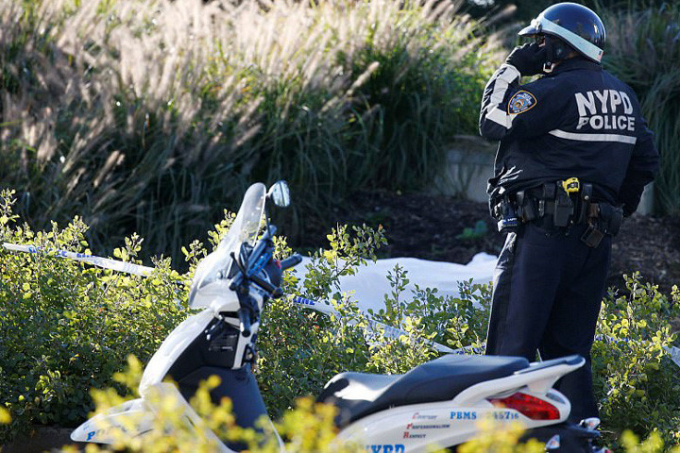 Một vi&ecirc;n cảnh s&aacute;t th&agrave;nh phố New York đứng b&ecirc;n thi thể nạn nh&acirc;n ở phần đường d&agrave;nh cho người đi xe đạp. Ảnh: Reuters.