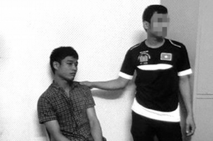 Đối tượng Thạnh (ngồi) l&uacute;c bị bắt.